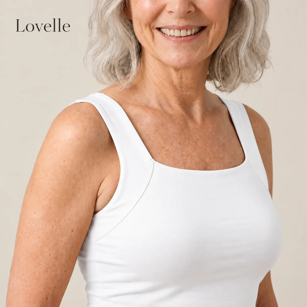 Smiling silver-haired woman wearing the Lovelle Ease built-in bra tank in white, square neckline and wide straps